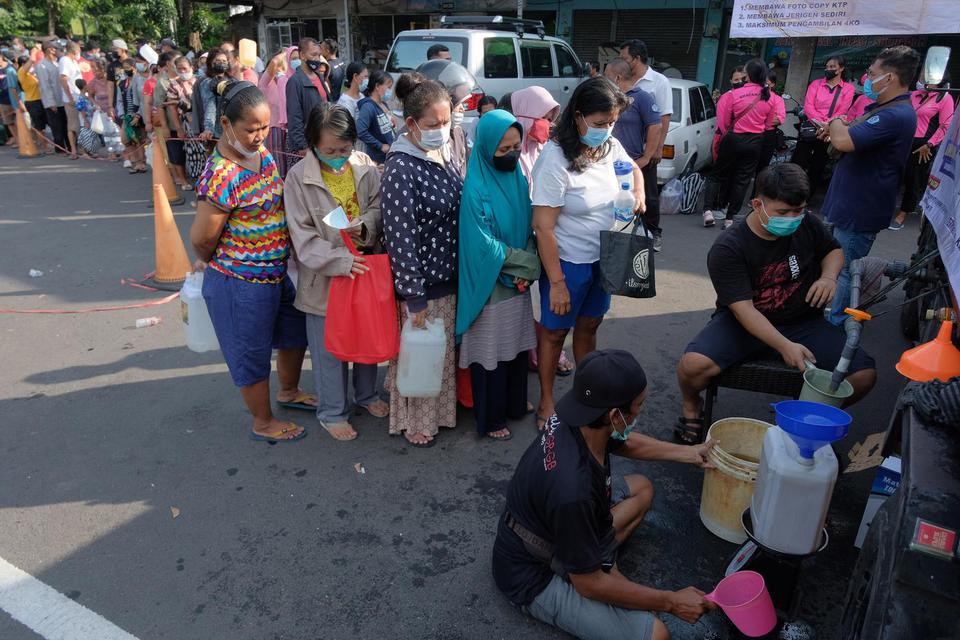 Warga antre membeli minyak goreng curah pada Gebyar 2 Ton Minyak Goreng Curah di Terminal Tegal, Denpasar, Bali, Sabtu (30/4/2022). Kegiatan yang digelar oleh Polsek Denpasar Barat bersama Karang Taruna Denpasar tersebut untuk membantu masyarakat memperol