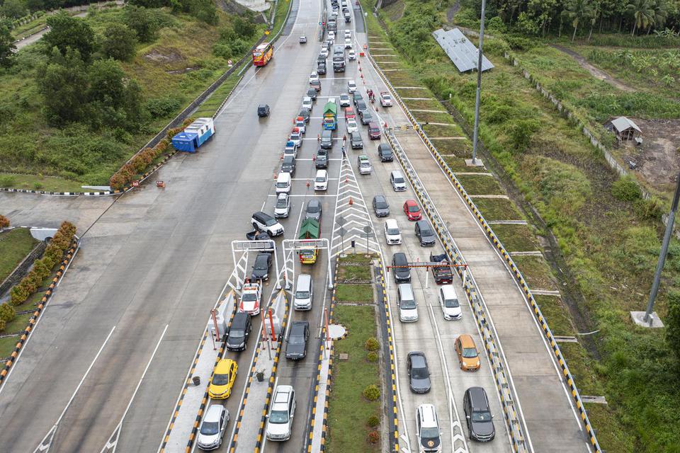 Sejumlah kendaraan pemudik antre melintasi Gerbang Tol Bakauheni Selatan, Lampung Selatan, Lampung, Minggu (1/5/2022).
