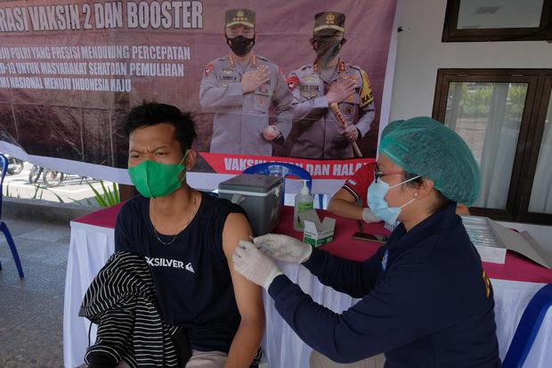 Petugas kesehatan menyuntikkan vaksin dosis ketiga kepada seorang wisatawan saat vaksinasi booster di kawasan objek wisata Tanah Lot, Tabanan, Bali, Rabu (4/5/2022). 