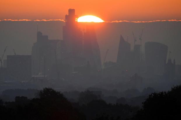 Toby Melville Matahari terbit di belakang gedung pencakar langit dan kantor-kantor distrik keuangan kota London di London, Britain, Kamis (5/5/2022).