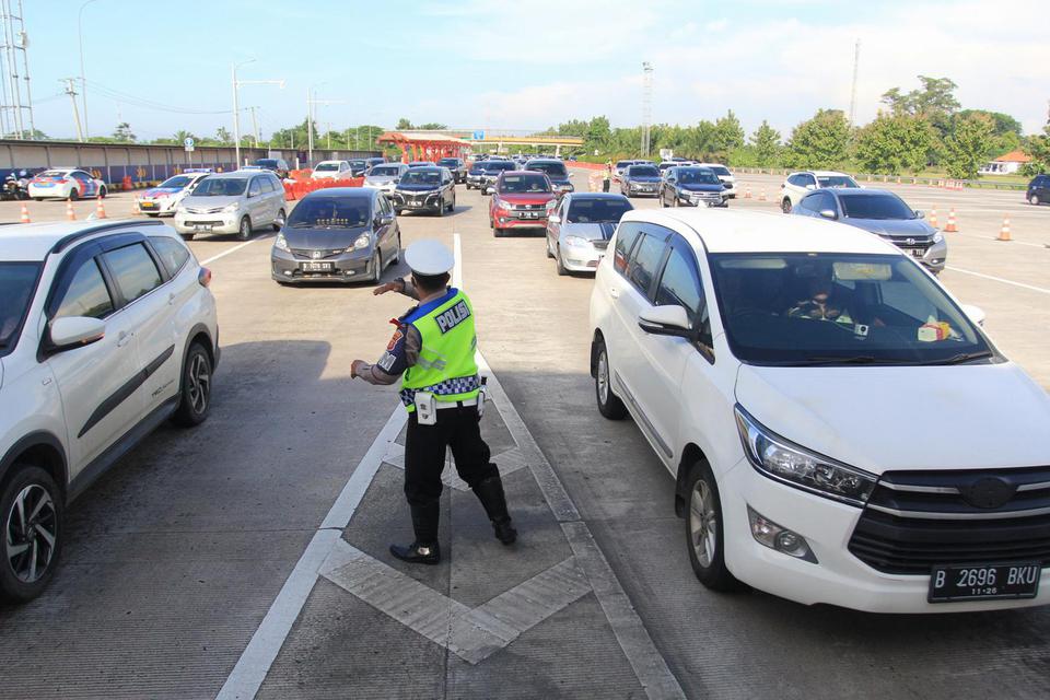 Polisi mengatur arus kendaraan saat penerapan jalur satu arah di gerbang Tol Cipali, Palimanan, Cirebon, Jawa Barat, Jumat (6/5/2022). 