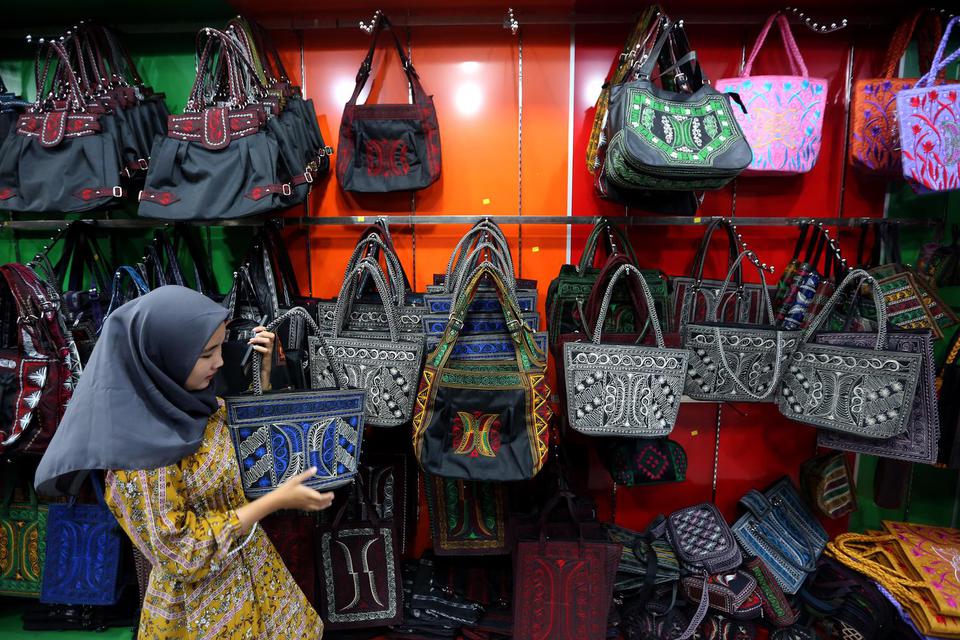 Wisatawan domestik memilih tas motif khas Aceh yaitu produk Usaha Mikro, Kecil dan Menengah (UMKM) yang ditawarkan di pusat oleh-oleh dan cenderamata Peunayong, Banda Aceh, Aceh, Sabtu (7/5/2022). 