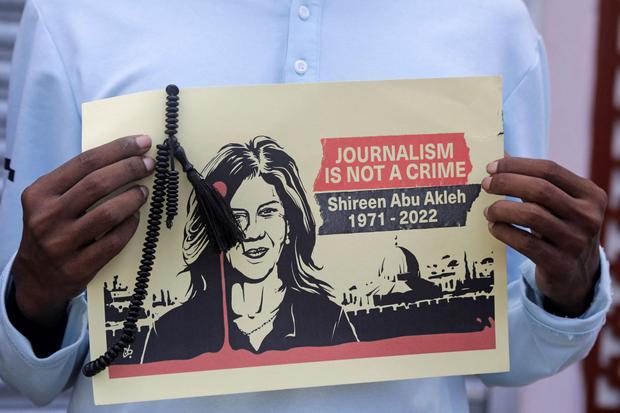 Feisal Omar Seorang jurnalis membawa plakat dengan gambar wartawan Al Jazeera Shireen Abu Akleh, yang tewas saat serangan Israel di wilayah pendudukan Tepi Barat area Jenin, ditengah aksi protes di Mogadishu, Somalia, Jumat (13/5/2022).