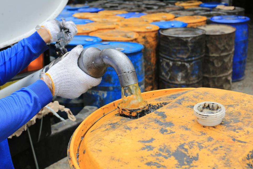 Pekerja membongkar minyak goreng curah di salah satu gudang distributor di Pasar Lambaro, Aceh Besar, Aceh, Sabtu (21/5/2022). Presiden Joko Widodo memutuskan untuk membuka larangan ekspor produk minyak sawit termasuk minyak goreng dan CPO mulai Senin, 23