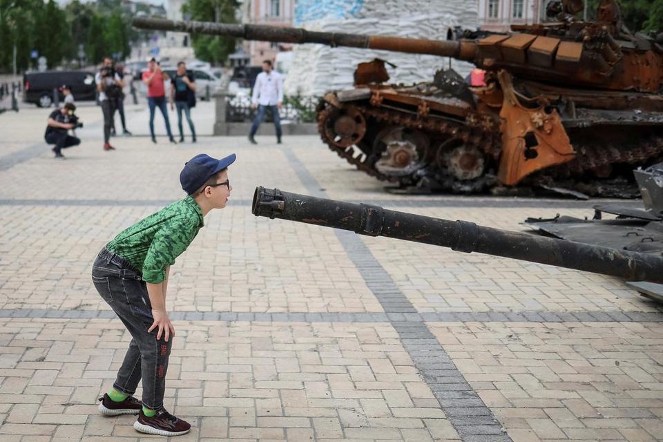 Gleb Garanich Seorang anak laki-laki melihat kendaraan tempur infanteri Rusia yang hancur selama pameran yang menampilkan kendaraan militer Rusia di tengah invasinya, di pusat Kyiv, Ukraina, Sabtu (21/5/2022).