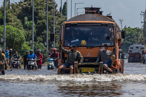 Ilustrasi, sejumlah pekerja pelabuhan menumpang truk untuk dapat menerobos banjir limpasan air laut ke daratan atau banjir rob yang merendam kawasan Pelabuhan Tanjung Emas, Semarang, Jawa Tengah, Selasa (24/5/2022).