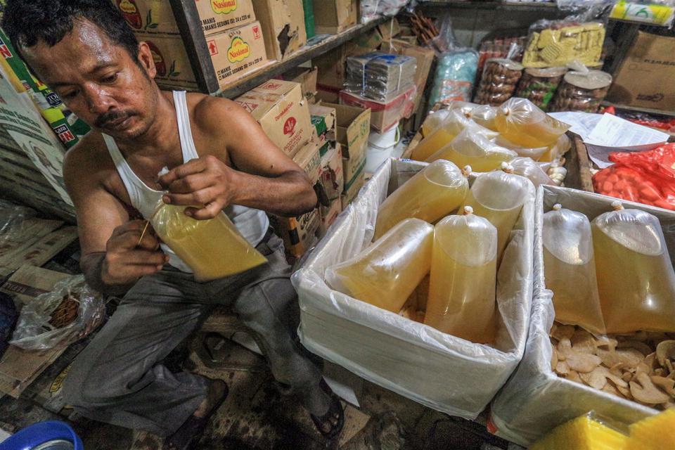 Pedagang mengemas minyak goreng curah yang dijual di Pasar Cibinong, Kabupaten Bogor, Jawa Barat, Rabu (25/5/2022). Pemerintah melalui Kementerian Perindustrian akan menghentikan program subsidi minyak goreng curah pada 31 Mei 2022, langkah tersebut diamb