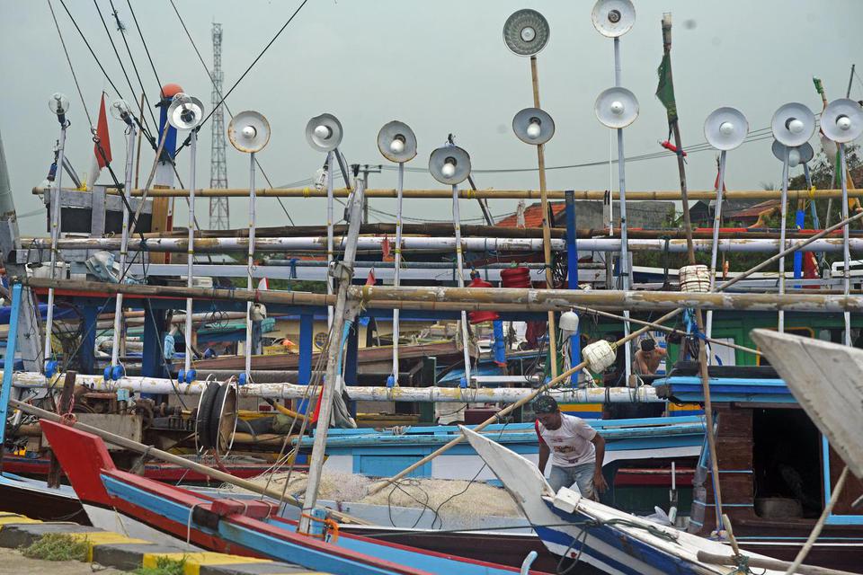 Nelayan memeriksa jaring di perahu yang ditambatkan di Dermaga I Pelabuhan Perikanan Nusantara (PPN) Karangantu, Serang, Banten, Kamis (26/5/2022). Sebagian besar nelayan setempat, kecuali pencari ikan di bibir pantai, tidak melaut terkait adanya peringat