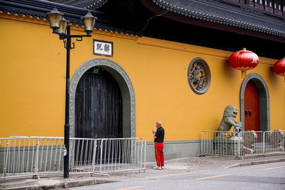 Aly Song Seorang pria berdoa di luar kuil yang ditutup saat penguncian, di tengah penyebaran penyakit virus korona (COVID-19) di Shanghai, China, Senin (30/5/2022).