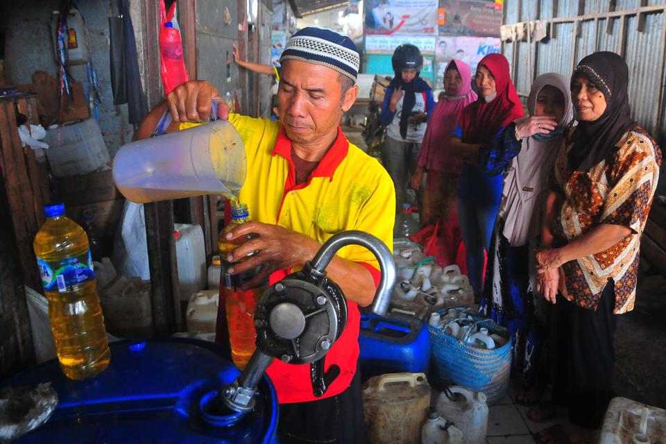 Pedagang melayani pembeli minyak goreng curah di Pasar Bitingan, Kudus, Jawa Tengah, Selasa (31/5/2022).