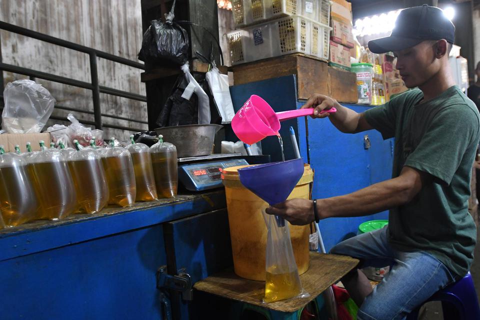 Pedagang memasukkan minyak goreng curah ke dalam kantong plastik di Pasar Senen, Jakarta, Selasa (31/5/2022). 