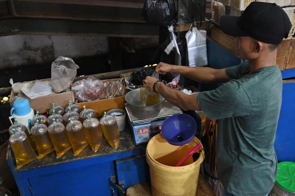 Pedagang menimbang minyak goreng curah yang dikemas di dalam kantong plastik di Pasar Senen, Jakarta, Selasa (31/5/2022).