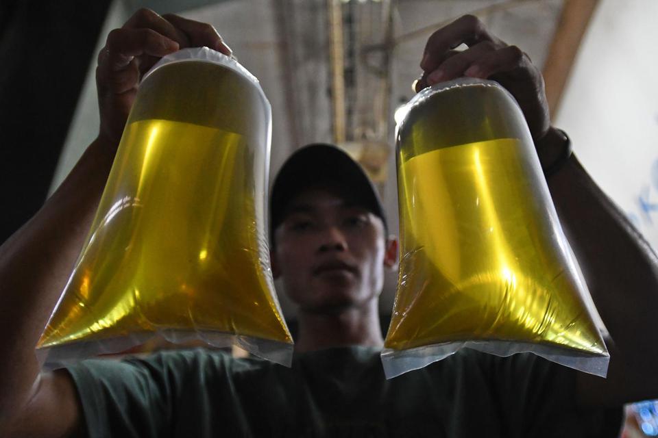Pedagang menunjukkan plastik berisi minyak goreng curah di Pasar Senen, Jakarta, Selasa (31/5/2022). Kementerian Perindustrian mencabut subsidi minyak goreng curah kepada pelaku usaha mulai Selasa (31/5/2022) menyusul dikeluarkannya Permendag Nomor 30 Tah