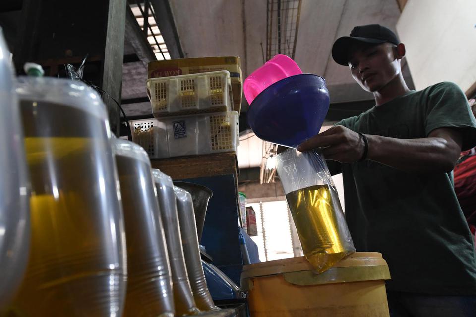 Pedagang memasukkan minyak goreng curah ke dalam kantong plastik di Pasar Senen, Jakarta, Selasa (31/5/2022). Kementerian Perindustrian mencabut subsidi minyak goreng curah kepada pelaku usaha mulai Selasa (31/5/2022) menyusul dikeluarkannya Permendag Nom