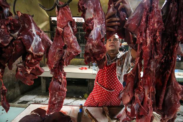 Pedagang menggantung daging sapi jualannya di Pasar Daging Tradisional Lhokseumawe, Aceh, Rabu (1/6/2022). Pedagang daging sapi mengaku penjualan daging turun hingga 75 persen yang biasanya 80 kilogram perhari menjadi 20 kilogram perhari akibat terdampak 