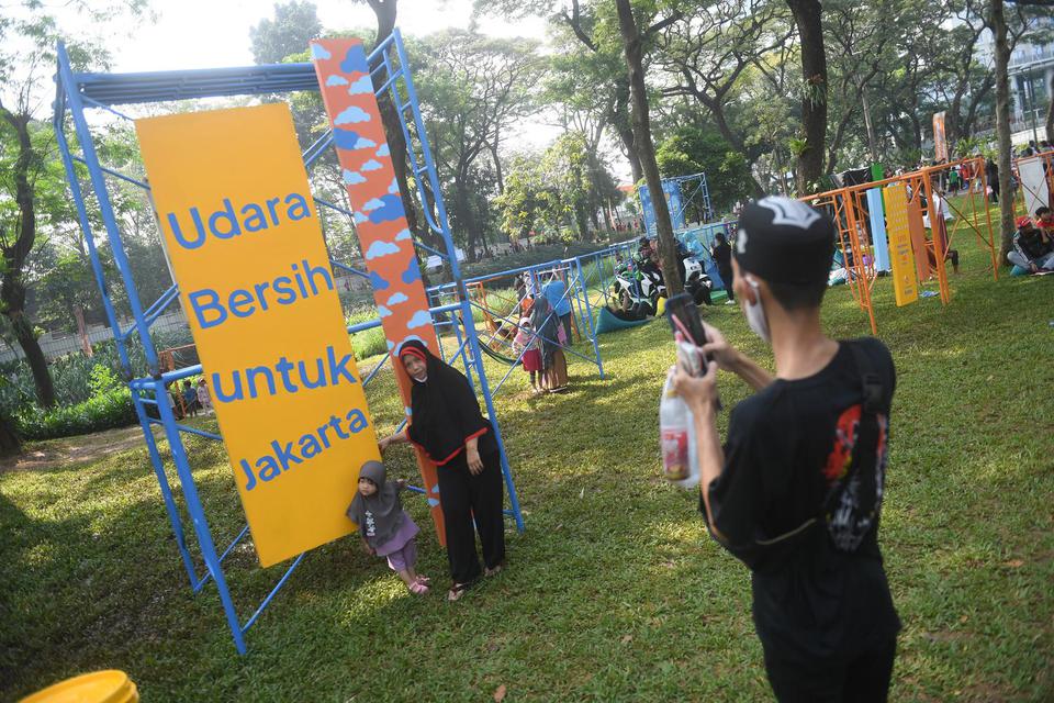 Pengunjung berfoto di depan instalasi Festival Hari Lingkungan Hidup 2022 di Tebet Eco Park, Jakarta, Minggu (5/6/2022). Festival itu mengangkat tema Udara Bersih untuk Jakarta.