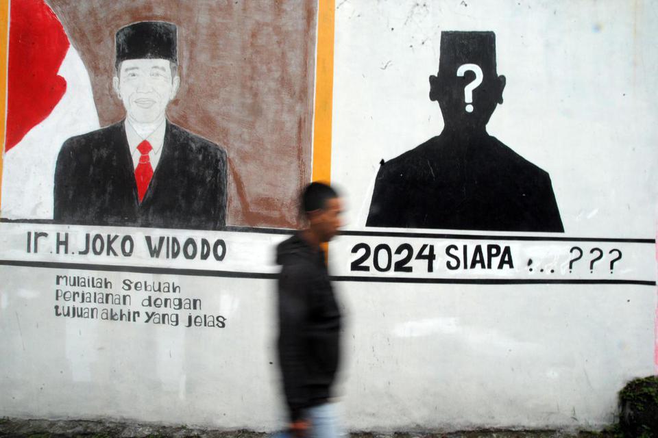 Seorang warga berjalan di dekat mural bergambar Presiden Joko Widodo di Kedung Halang, Kota Bogor, Jawa Barat, Senin (13/6/2022). 