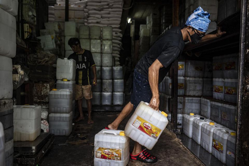 Pekerja memindahkan jerigen berisi minyak goreng curah di kawasan Kebayoran Lama, Jakarta, Kamis (16/6/2022). Pemerintah berencana akan melakukan peralihan secara bertahap dari perdaganganan minyak goreng curah ke minyak goreng kemasan sederhana.
