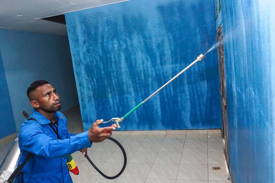 Petugas Puskesmas Jaifuri Arso III Ilham Sangaji menyemprotkan cairan penangkal nyamuk penyebab penyakit malaria ke dinding rumah warga di Kampung Arsopura, Skanto, Keerom, Papua, Selasa (21/6/2022). Penyemprotan secara gratis ke rumah-rumah warga itu seb