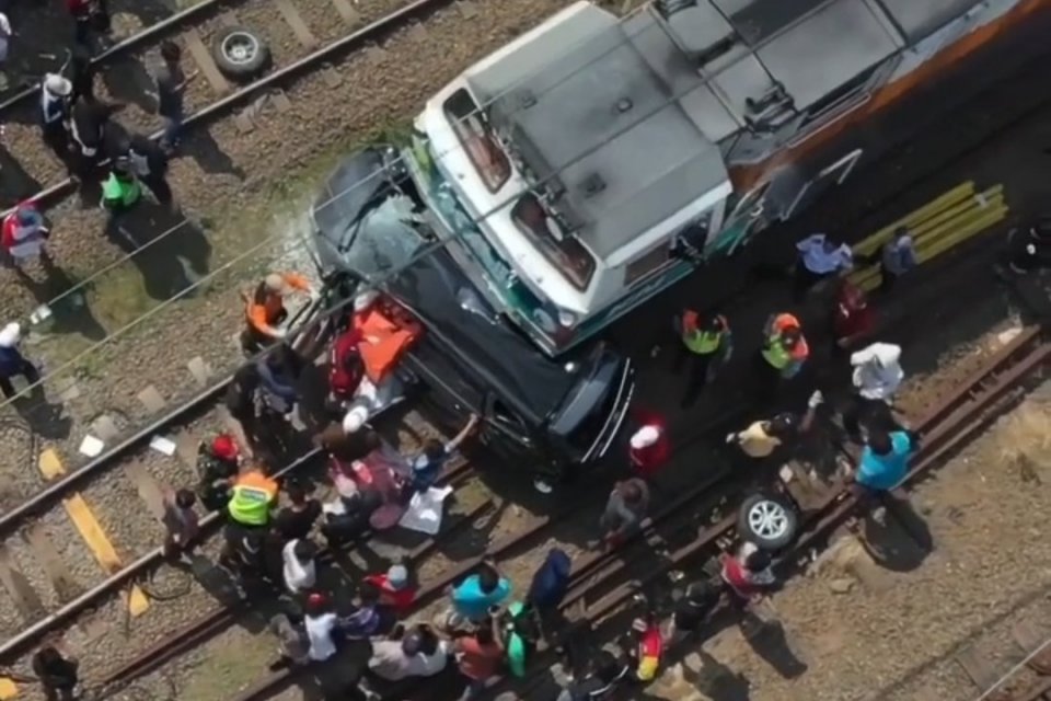 Petugas melakukan evakuasi terhadap mobil yang tertabrak kereta api Argo Sindoro, Selasa (21/6).