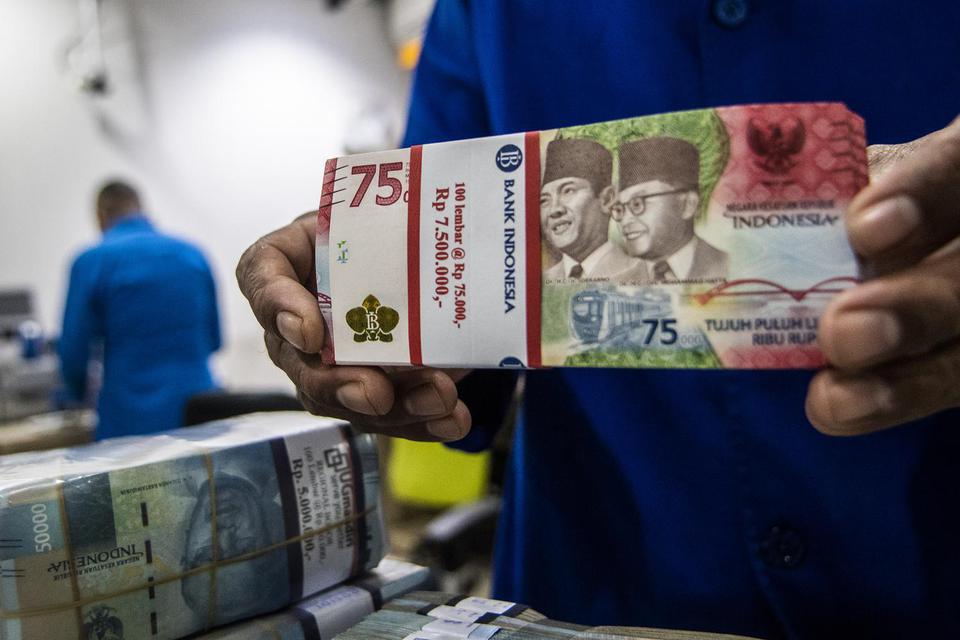 Petugas menyusun tumpukan uang di Cash Pooling Bank Mandiri, Jakarta, Kamis (23/6/2022). Dewan Gubernur Bank Indonesia pada Juni 2022 memutuskan untuk mempertahankan suku bunga acuan sebesar 3,5 persen, dikarenakan inflasi inti masih di bawah tiga persen 