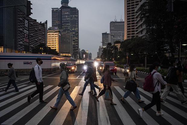 Warga menyeberang jalan di Jalan Jenderal Sudirman, Jakarta, Jumat (24/6/2022). 