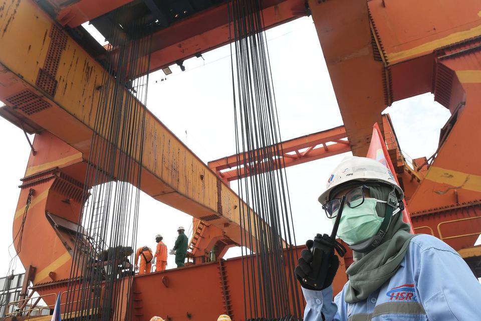 Seorang pekerja memberikan arahan saat menyelesaikan pemasangan girder box di pembangunan Proyek Kereta Cepat Jakarta-Bandung (KCJB) di Jatibening, Bekasi, Jawa Barat, Senin (27/6/2022). Pemasangan girder box proyek KCJB sudah rampung dengan total 1.018 