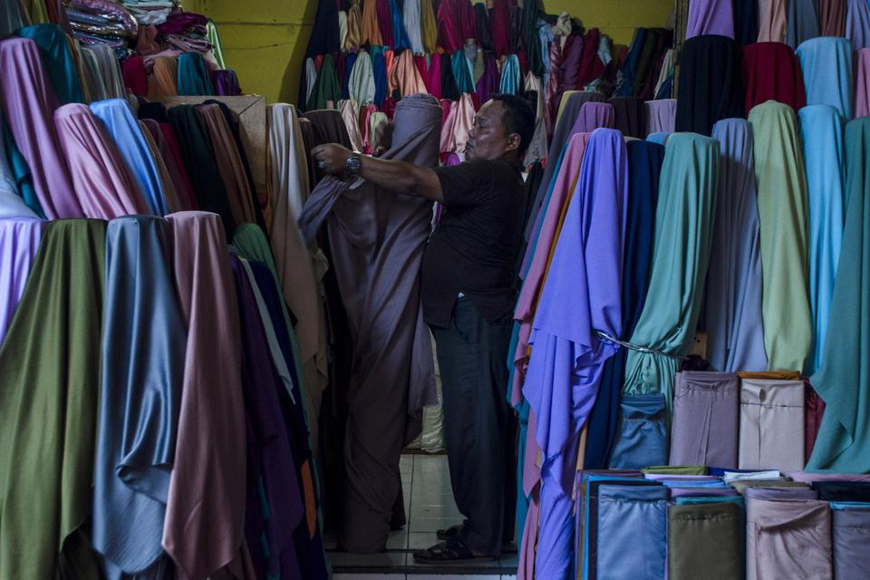 Pedagang merapikan produk tekstil yang dijual di Kampung Wisata Kreatif Tekstil Cigondewah, Bandung, Jawa Barat, Rabu (29/6/2022). 