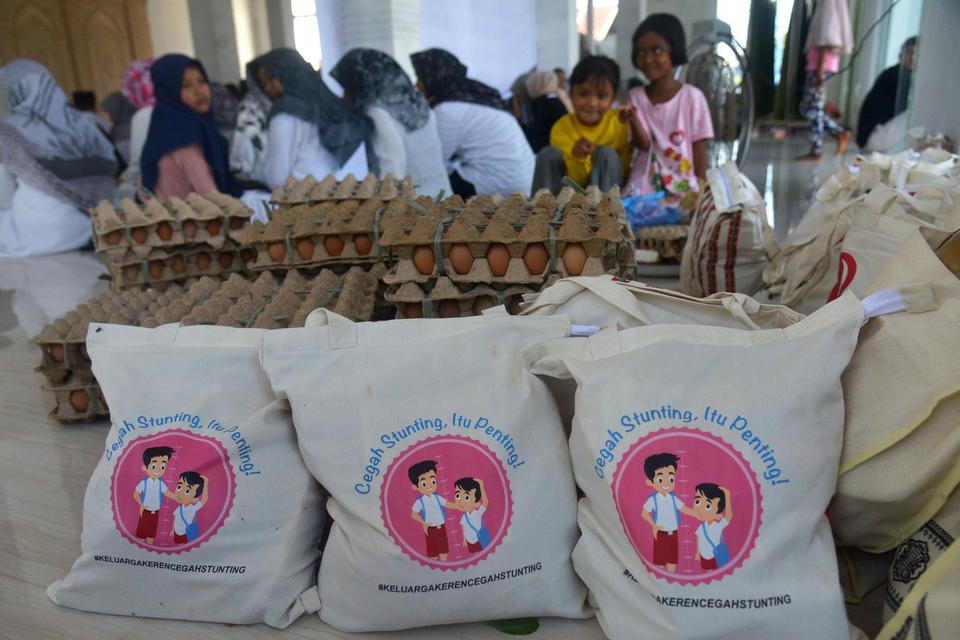 Sejumlah warga mengikuti acara pemberikan paket bantuan sosial untuk keluarga beresiko stunting di Masjid Desa Bak Sukon, Kabupaten Aceh Besar, Aceh, Rabu (29/6/2022). 