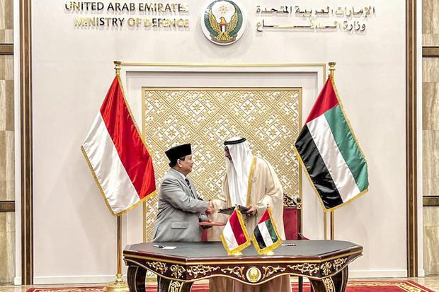 Menteri Pertahanan (Menhan) Prabowo Subianto (kiri) berjabat tangan dengan Menhan Uni Emirat Arab (UEA) Mohammed Ahmed Al Bowardi (kanan) usai menandatangani dokumen kerja sama di kantor Kementerian Pertahanan UEA, Abu Dabi, UEA, Kamis (30/6/2022). 