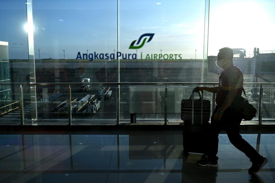 Penumpang pesawat udara berjalan membawa barang bawaan di Terminal Domestik Bandara Internasional I Gusti Ngurah Rai, Badung, Bali, Rabu (6/7/2022). Pengelola Bandara Bali menargetkan 9 juta orang penumpang sepanjang tahun 2022 dan pada periode Januari-Ju