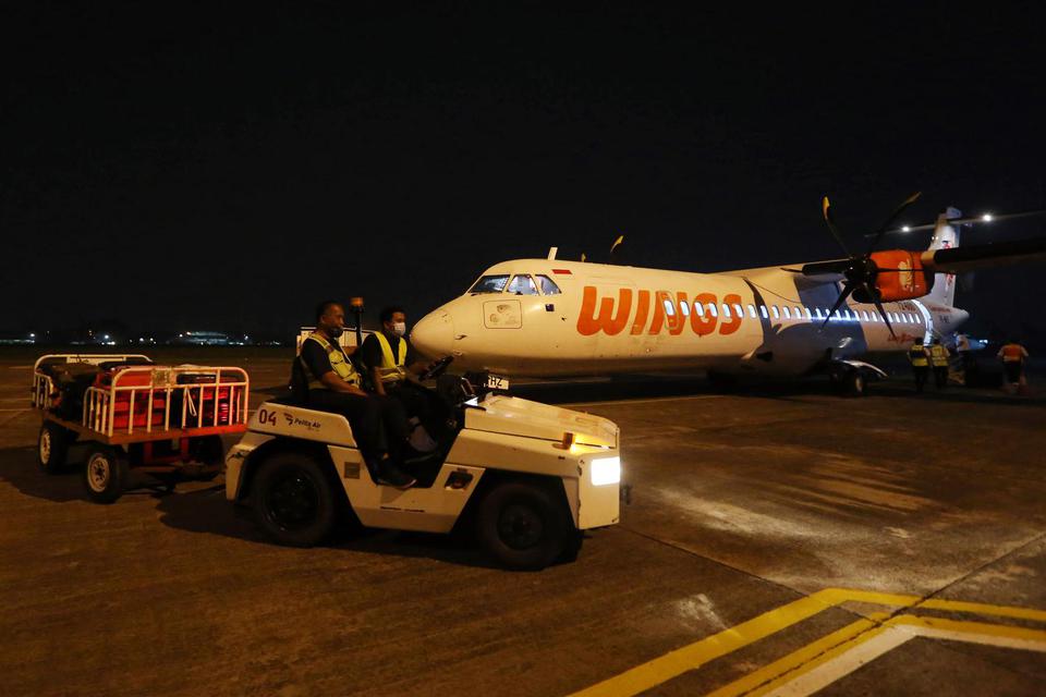 Petugas kargo melakukan bongkar muat bagasi dari Pesawat ATR 72 Wings Air yang baru mendarat dari Bandara Tunggul Wulung Cilacap di Apron Bandara Pondok Cabe, Tangerang Selatan, Banten, Rabu (6/7/2022). Maskapai Wings Air melakukan uji coba pendaratan dan