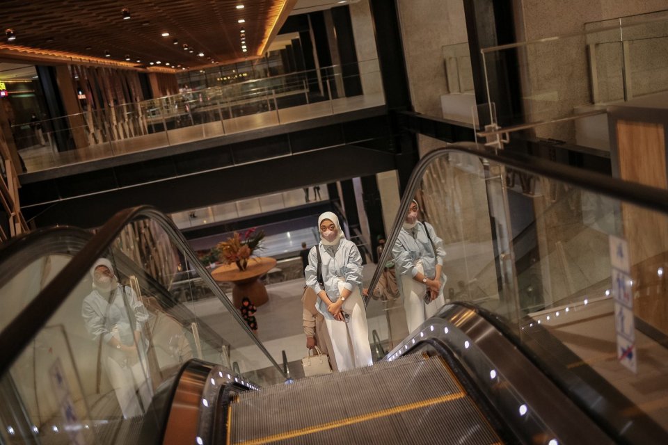 Pengunjung menggunakan masker wajah saat menaiki eskalator di Mal Sarinah, Jakarta, Rabu (6/7). Pemerintah mengubah status Pembatasan Kegiatan Masyarakat (PPKM) di DKI Jakarta dan sekitarnya kembali ke level satu mulai Rabu(6/7). 