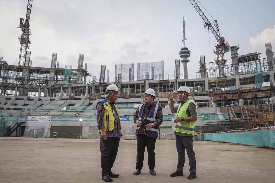 Menteri PUPR Basuki Hadimuljono (kiri) berbincang dengan Menpora Zainudin Amali (kanan) dan Menteri BUMN Erick Thohir (tengah) saat meninjau proyek pembangunan Indoor Multifunction Stadium di Kompleks GBK, Senayan, Jakarta, Jumat (8/7/2022). Pembangunan s