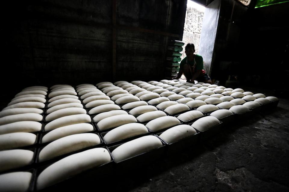 Pekerja menata adonan roti sebelum dipanggang di salah satu usaha roti Dicky Bakery di Depok, Jawa Barat, Senin (11/7/2022). Pemilik roti mengaku beberapa pekan terakhir telah mengurangi jumlah produksi akibat permintaan menurun dan harga bahan baku tepun