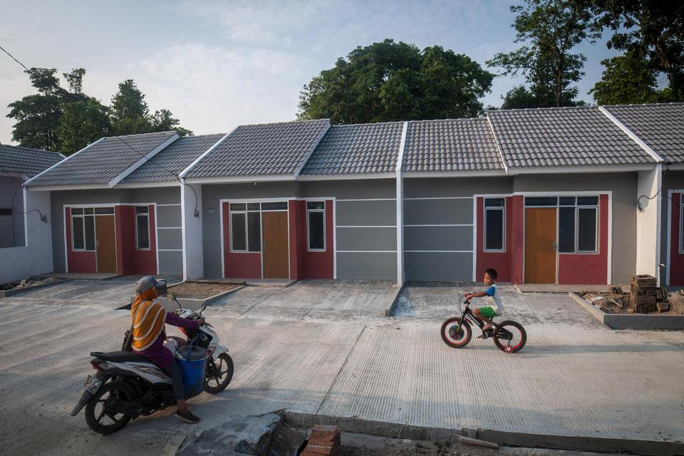 Warga melintas di salah satu kompleks perumahan bersubsidi di Pandeglang, Banten, Senin (11/7/2022). Pemerintah melalui program Fasilitas Likuiditas Pembiayaan Perumahan (FLPP) menargetkan sebanyak 200 ribu unit rumah bersubsidi akan dibangun di tahun 202