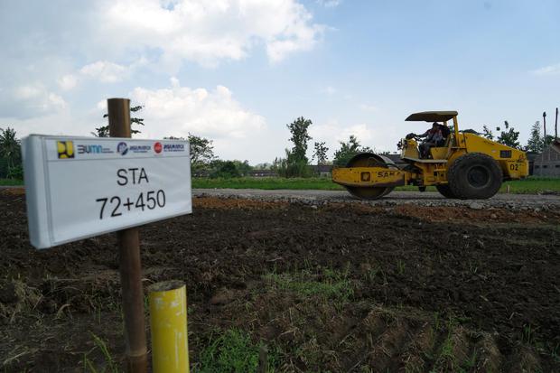 Operator mengoperasikan alat berat saat melakukan pengerasan tanah pada pembangunan Tol Yogyakarta-Bawen Seksi 1 di Seyegan, Sleman, D.I Yogyakarta, Selasa (12/7/2022). 
