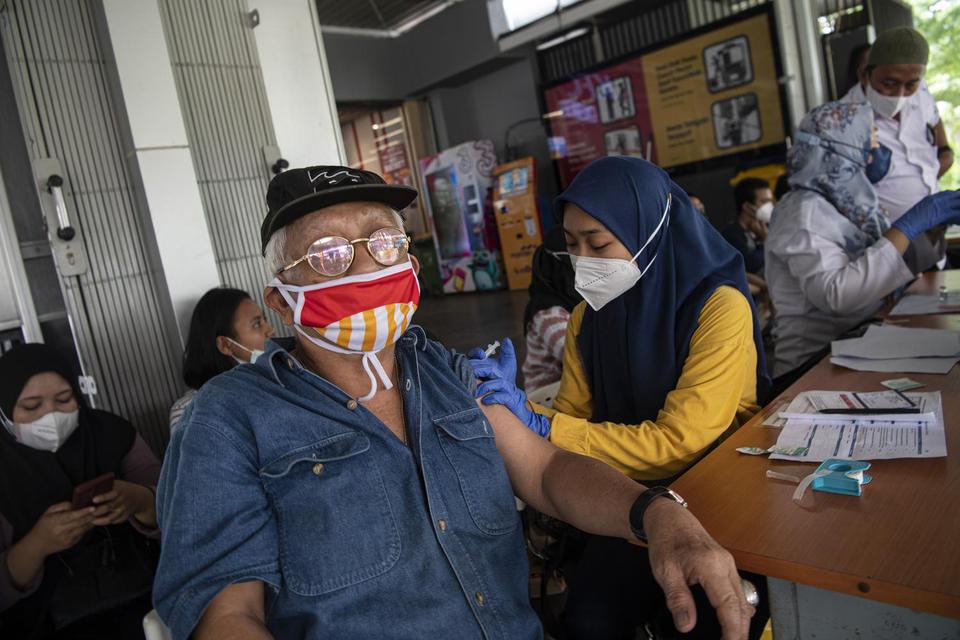 Warga mendapat suntikan vaksin COVID-19 di Stasiun Manggarai, Jakarta Selatan, Rabu (13/7/2022). 