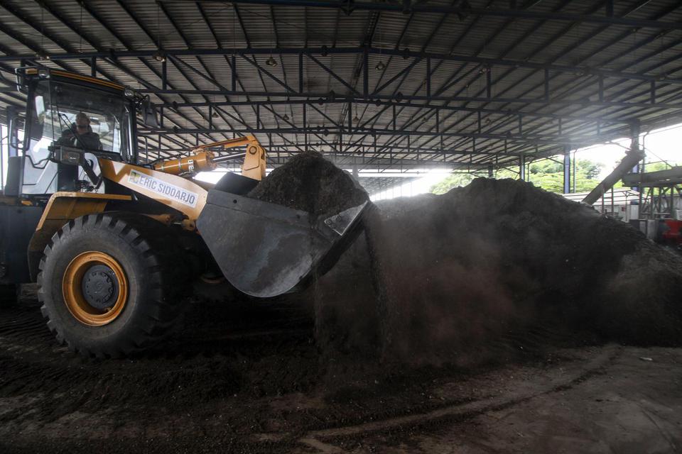 Pekerja mengoperasikan alat berat mengeruk bahan baku pengganti batu bara (co-firing) biomassa yang berasal dari sampah di Tempat Pembuangan Akhir (TPA) Sampah di Jabon, Sidoarjo, Jawa Timur, Rabu (13/7/2022). 