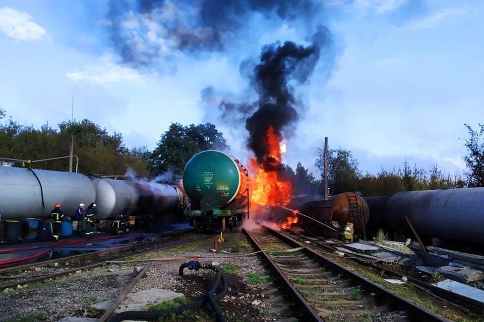 Firefighters gather near tank cars as they work to extinguish a fire at an oil depot in the Budyonnovsky district of Donetsk, Ukraine, in this handout image released by the self-proclaimed Donetsk People's Republic's emergencies ministry July 26, 2022. 