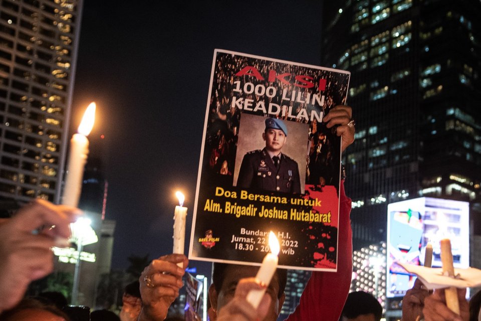 Peserta aksi dari Tim Advokat Penegakan Hukum dan Keadilan (TAMPAK) mengangkat poster saat aksi seribu lilin dan doa bersama untuk Alm Brigadir Yosua Hutabarat di Bundaran HI, Jakarta, Jumat (22/7/2022). 