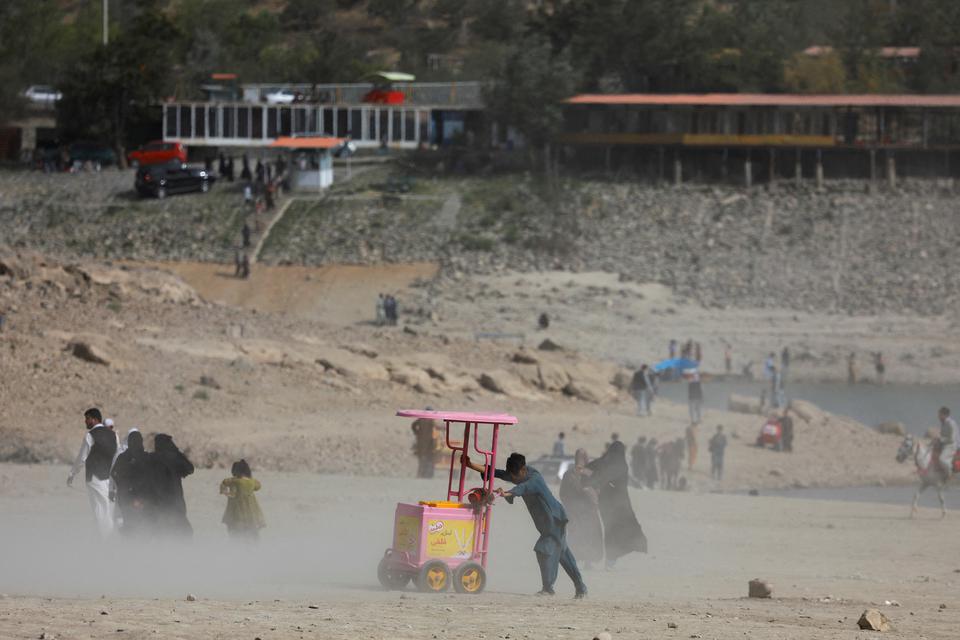 A person pushes his cart during a dust storm in Qargha lake in Kabul, Afghanistan, July 29, 2022.