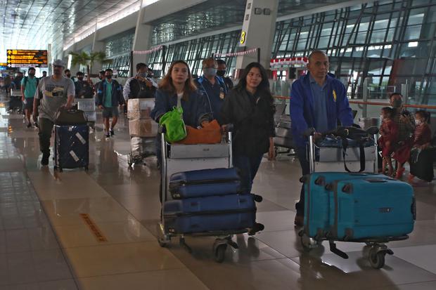 Calon penumpang melintas di selasar Terminal 3 Bandara Soekarno Hatta, Tangerang, Banten, Senin (8/8/2022). 