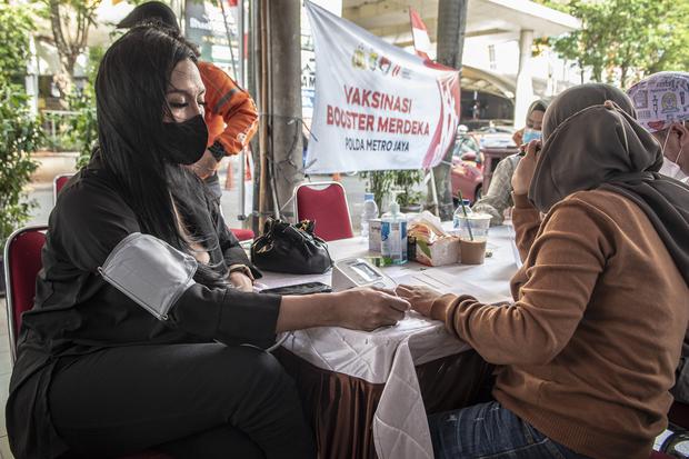 Petugas kesehatan memeriksa kesehatan calon penerima vaksin booster COVID-19 di kawasan Blok M, Jakarta, Minggu (14/8/2022). 
