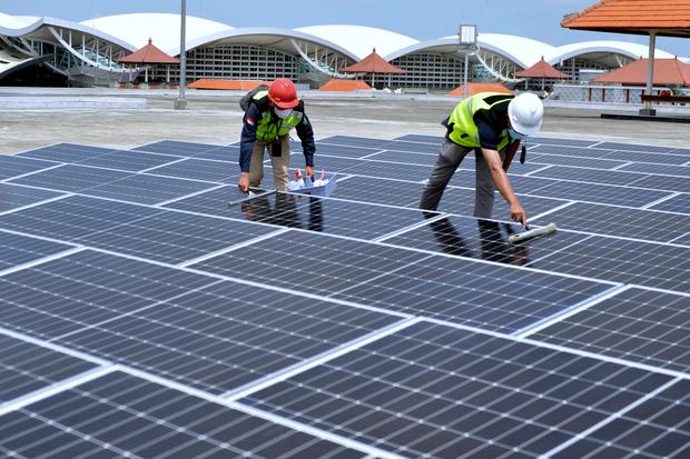 Petugas melakukan perawatan panel surya pada Pembangkit Listrik Tenaga Surya (PLTS) di Bandara I Gusti Ngurah Rai, Badung, Bali, Rabu (21/9/2022). Angkasa Pura I mengoperasikan PLTS untuk menyuplai energi listrik di gedung parkir bandara sebagai upaya men