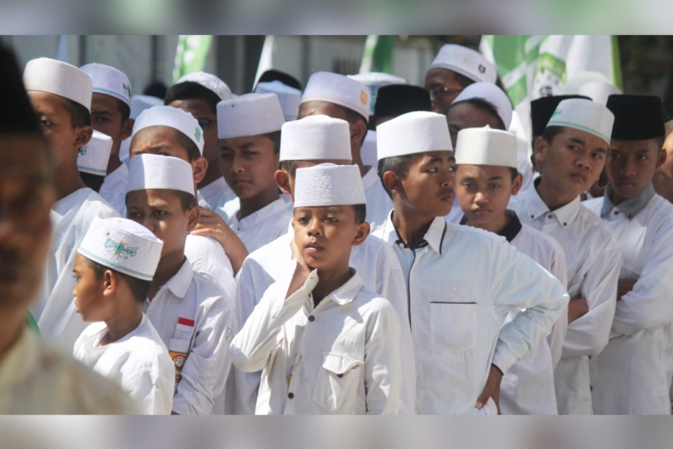 Dalam memperingati Hari Santri Nasional, para santri mengenakan pakaian serba putih sedang berbaris 