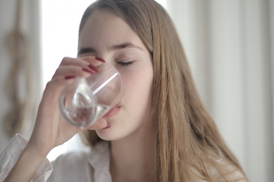 Ilustrasi, seorang wanita minum air garam. Manfaat minum air garam antara lain meningkatkan kualitas tidur, mencegah dehidrasi, mengurangi stres, menurunkan berat badan, memperbaiki fungsi otot, dan membantu fungsi saraf.