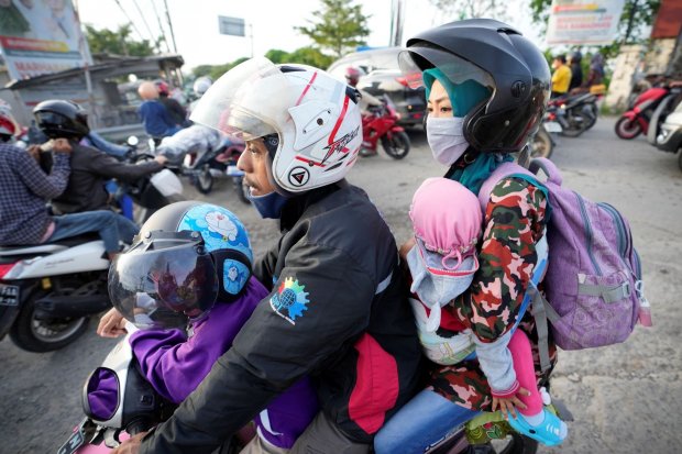 Keluarga melakukan mudik dengan naik motor