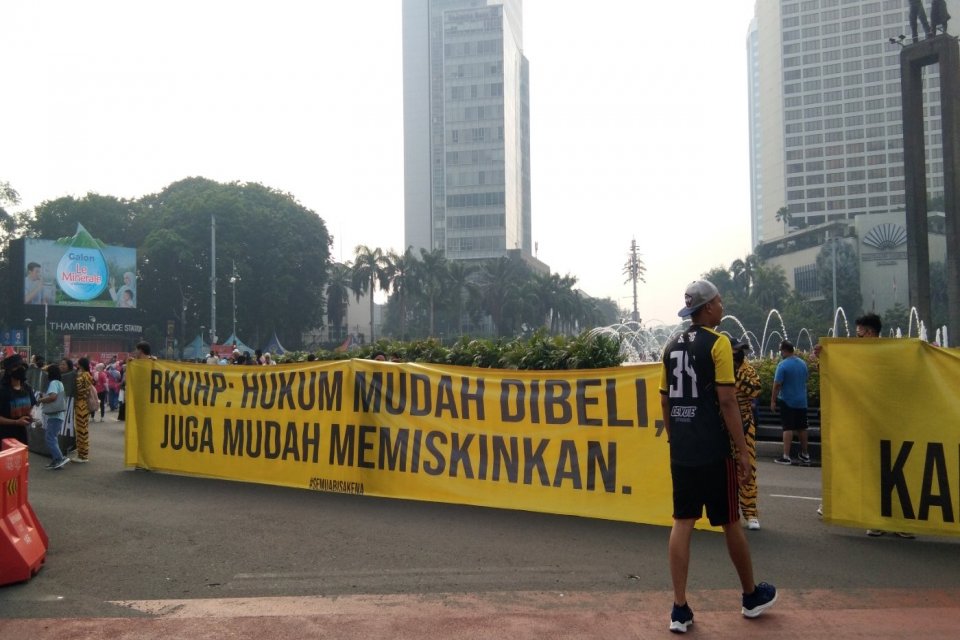 Aktivis membentangkan spanduk penolakan RUKHP