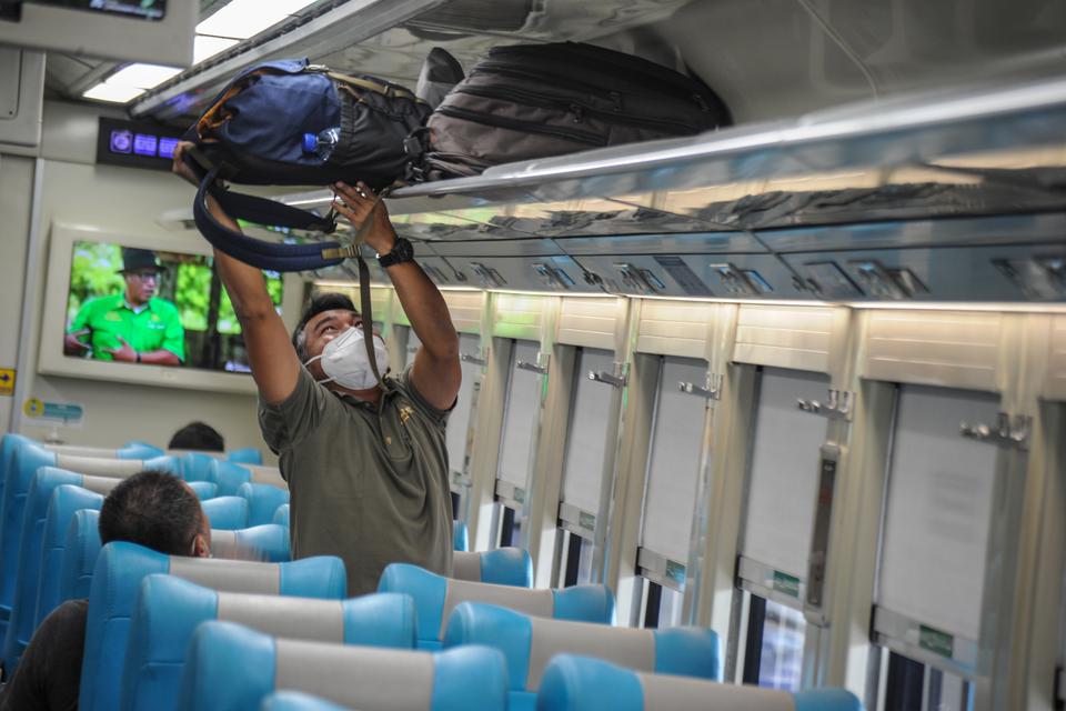 Penumpang meletakkan barang di dalam gerbong kereta api Argo Parahyangan tujuan Jakarta di Stasiun Bandung, Jawa Barat, Jumat (9/12/2022). 